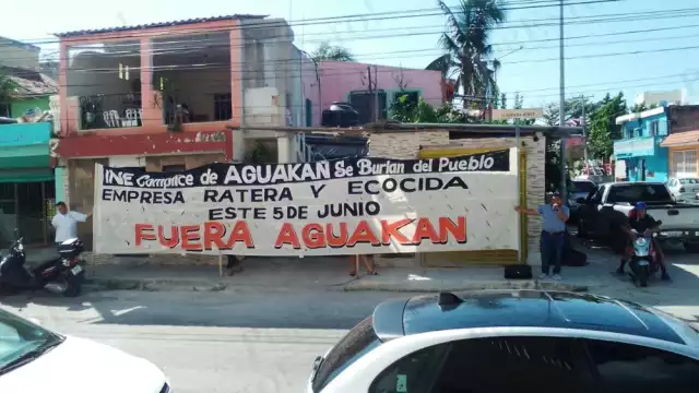 Una manta fue extendida afuera de la sede del INE en Playa del Carmen por manifestantes para mostrar su rechazo a Aguakan