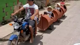 El papá jalaba el tren con una moto por las calles de Maní, Yucatán