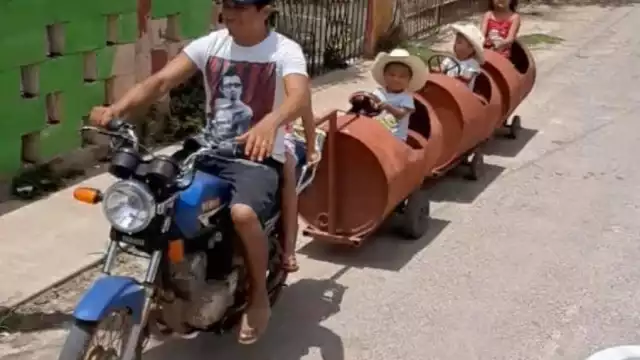 El papá jalaba el tren con una moto por las calles de Maní, Yucatán
