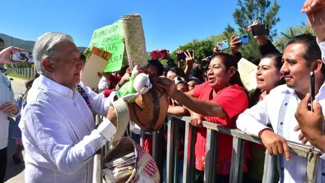Al acercarse a saludar a los asistentes, el mandatario federal recibió todo tipo de obsequios
