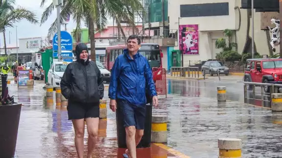En la Zona Hotelera se observó a grupos de turistas con impermeables y paraguas o entrando a las plazas comerciales