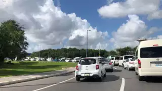 Se formó una fila de vehículos que esperan entrar a las terminales del Aeropuerto de Cancún