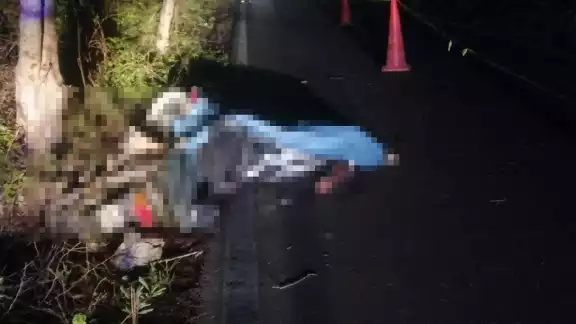La motocicleta quedó tirada a un costado de la calle con él todavía montado en ella La motocicleta quedó tirada a un costado de la calle con él todavía montado en ella