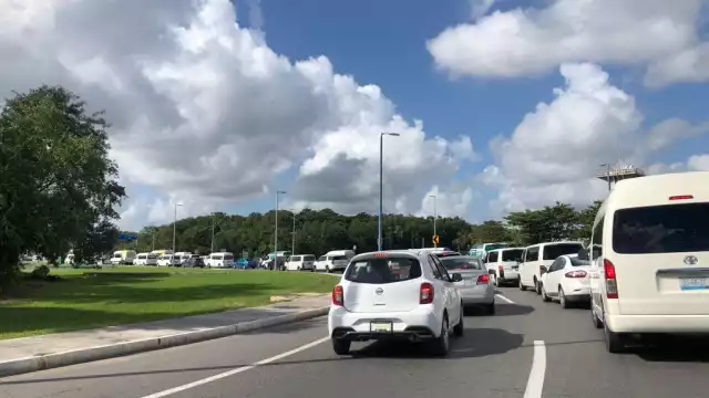 Se formó una fila de vehículos que esperan entrar a las terminales del Aeropuerto de Cancún