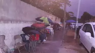 Adultos mayores hacen fila durante la lluvia en Chetumal