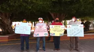 Los trabajadores del sistema de agua exhibieron unas cartulinas alusivas para pedirle a las empresas