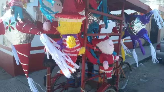 Don Isidro lleva en su triciclo piñatas de todo tipo, desde estrellas hasta a Santa Claus Don Isidro lleva en su triciclo piñatas de todo tipo, desde estrellas hasta a Santa Claus
