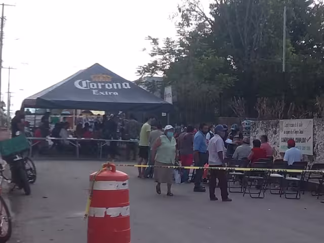 Los abuelitos esperaban su turno debajo de una lona colocada sobre la calle