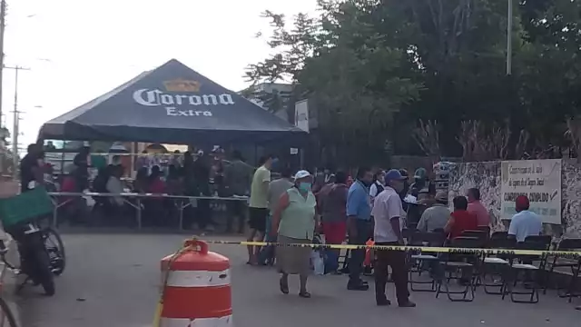 Los abuelitos esperaban su turno debajo de una lona colocada sobre la calle