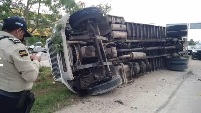 Un camión Freightliner tipo caja cerrada, colisionó con un volquete y se volcó sobre el costado derecho.