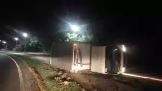 El chofer tomó demasiado rápido la curva y derivado del peso terminó recostado a un lado de la vía