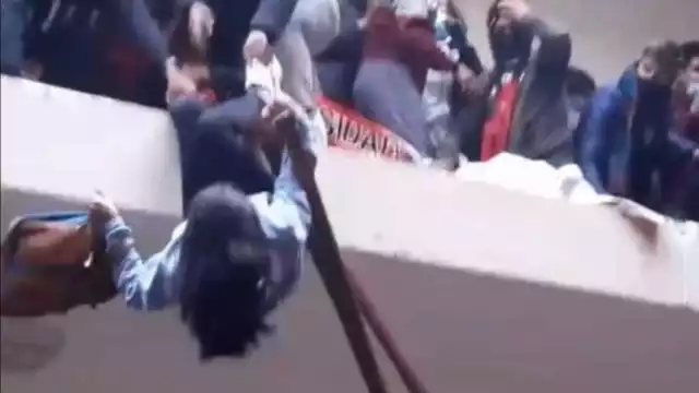 Momento en el que una estudiante es rescatada por sus compañeros de caer al vacío