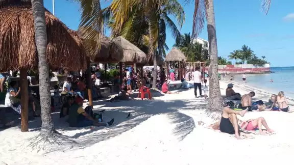 Bañistas disfrutan del sol, la arena y el mar en Playa del Niño Bañistas disfrutan del sol, la arena y el mar en Playa del Niño