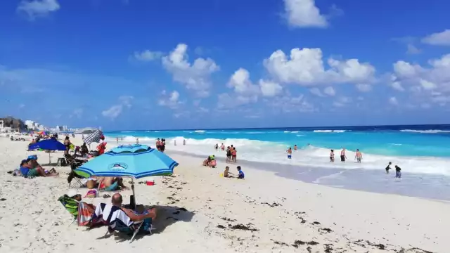 cancunenses disfrutan de la playa 
