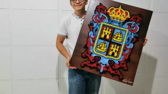 Mauricio Moore posa con su obra de arte