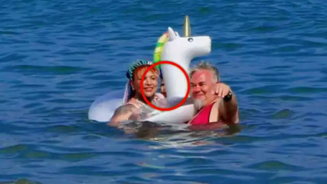 El rostro de una persona aparece detrás de la pareja