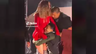 El fan logró burlar la seguridad para subir al escenario junto a Belinda. Foto: Especial