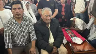 El padre del sacerdote Marcelo Pérez junto al ataud donde se encuentran el cuerpo de su hijo, asesinado el domingo pasado en Chiapas