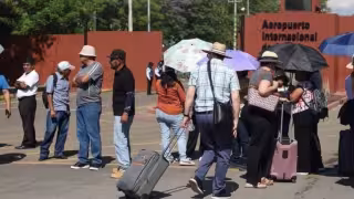 CNTE bloquea accesos al Aeropuerto de Oaxaca por tercera vez; pasajeros caminan para llegar a sus vuelos