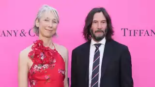 Keanu Reeves y Alexandra Grant compartiendo alfombra durante el evento