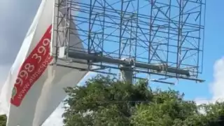 Lona publicitaria a punto de caer genera riesgo vial en la vía Playa del Carmen-Tulum