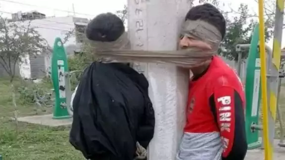 Los hombres fueron amarrados de pies a cabeza a un poste de luz Los hombres fueron amarrados de pies a cabeza a un poste de luz