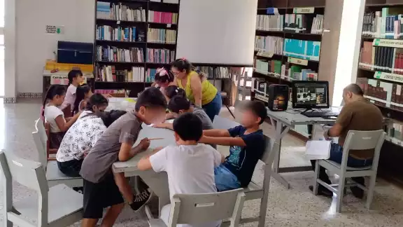 Las bibliotecarias están trabajando con los niños y niñas diversas actividades recreativas Las bibliotecarias están trabajando con los niños y niñas diversas actividades recreativas