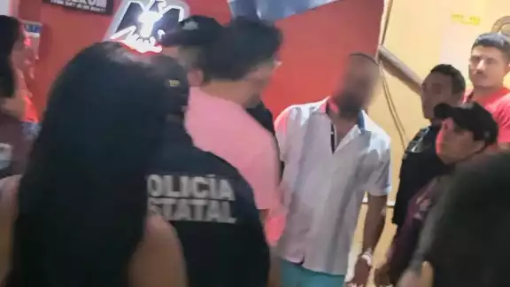 El extranjero se entregó a la policía y fue escoltado lejos de la multitud El extranjero se entregó a la policía y fue escoltado lejos de la multitud