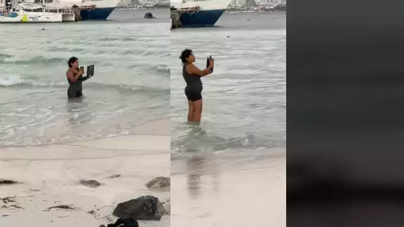 Se ve a la mujer contestando llamadas mientras está dentro del mar Se ve a la mujer contestando llamadas mientras está dentro del mar