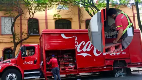 El repartidor llenaba botellas de 600 ml con una de 3 litros de Coca Cola El repartidor llenaba botellas de 600 ml con una de 3 litros de Coca Cola