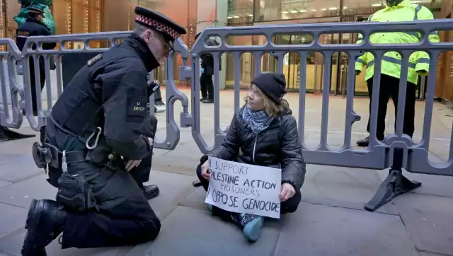 Imágenes difundidas en redes sociales muestran a la activista Greta Thunberg sentada en el suelo con la pancarta momentos antes de su detención
