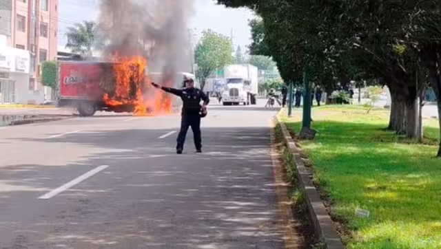 Normalistas en Morelia protestan e incendian camión de reparto.