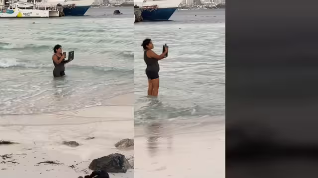 Se ve a la mujer contestando llamadas mientras está dentro del mar