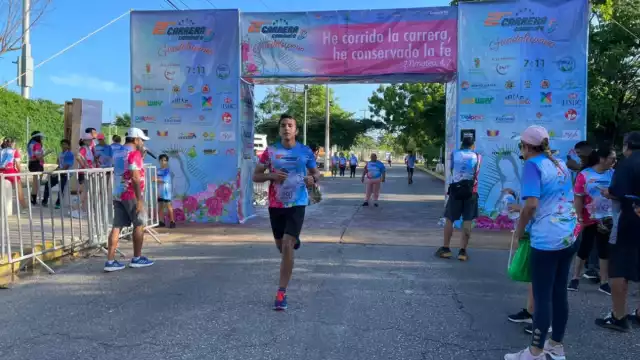 La lluvia matutina no fue impedimento para que los corredores enfundados en la playera conmemorativa en azul