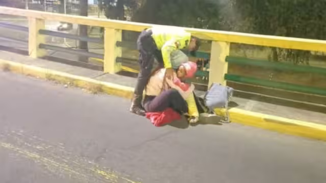 La mujer se encontraba sentada en el barandal con su bebé en brazos