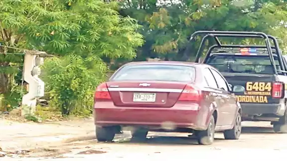 La unidad número 6484 de la SSP permanece frente al predio donde fue encontrada la bolsa con el cadáver. Foto: Por Esto!