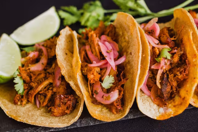El taco de cochinita pibil se acompaña con cebolla morada y chile habanero