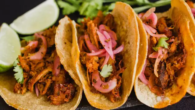 El taco de cochinita pibil se acompaña con cebolla morada y chile habanero