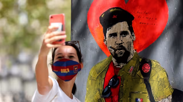 Una mujer se toma una selfie con la imagen de Messi como el Che Guevara (Reuters)