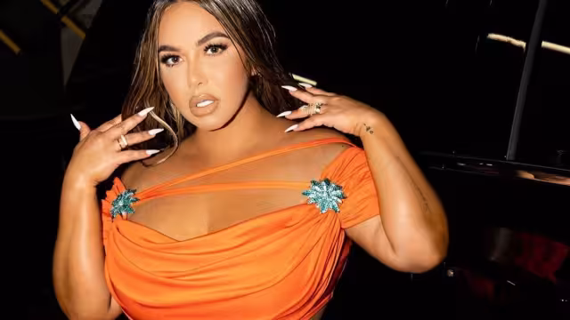 La cantante lució un entallado vestido naranja que despertó las críticas entre los haters de redes sociales