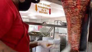 Taquero en San Diego prepara una orden de pastor