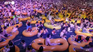 La gente disfruta de un show mientras se refresca en una piscina en Wuhan (AFP)