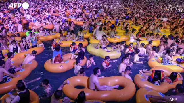 La gente disfruta de un show mientras se refresca en una piscina en Wuhan (AFP)