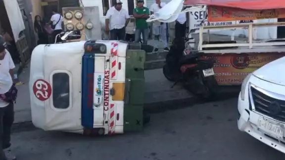 La unidad de mototaxi rotulada con el número 29 quedó de costado junto a un puesto ambulante luego de ser impactado por un conductor en Playa del Carmen