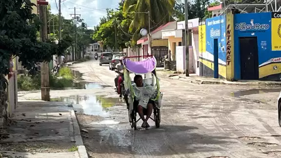José Uh recorre en silla de ruedas varios kilómetros para recibir terapias que le brinden mayor movilidad.