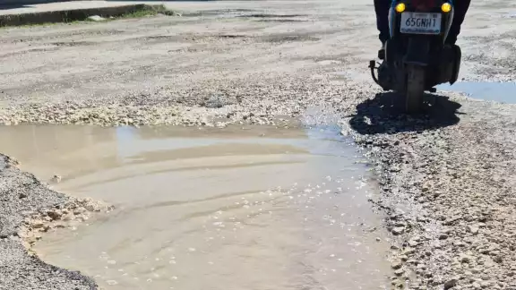 Algunos de los baches son enormes en la transitada vía. Algunos de los baches son enormes en la transitada vía.