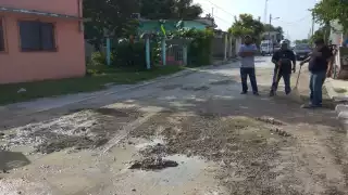 Debido a que autoridades no responden a las denuncias, vecinos se reunieron para cubrir los baches de la calle por sus medios