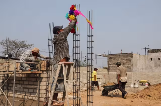 Albañil coloca una cruz adornada