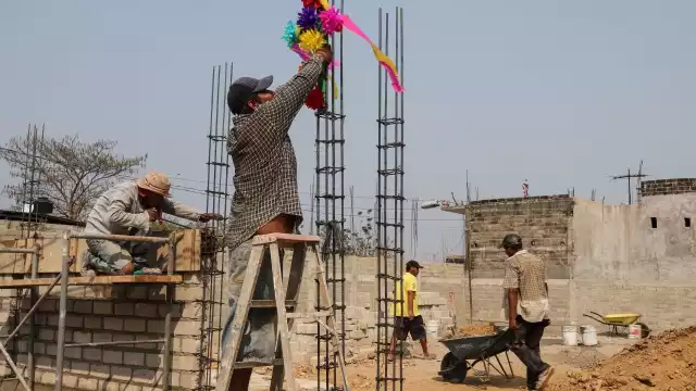 Albañil coloca una cruz adornada