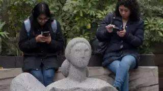 Dos jóvenes en sus teléfonos celulares